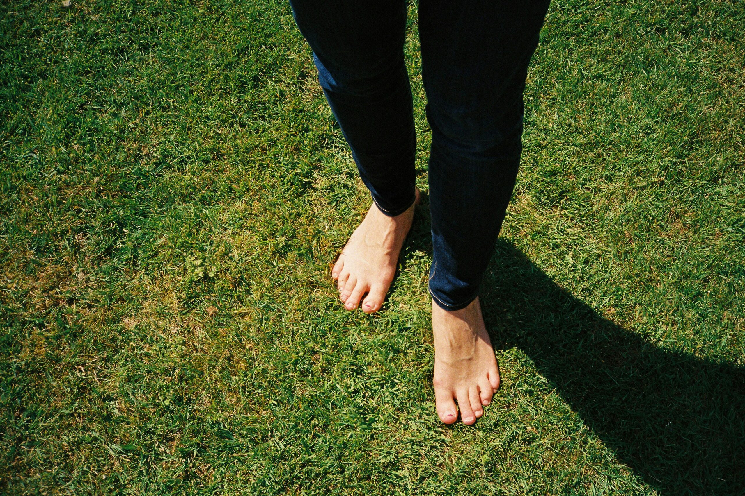 Barefoot grounding on green grass showing earthing therapy practice for daily wellness
