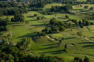 Aerial view of golf course with homes nearby showing pesticide exposure risk for families living near golf courses