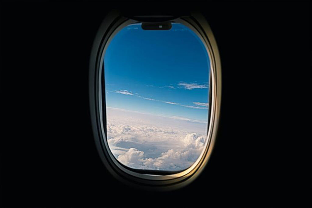 Airplane window seat with UV exposure at high altitude - why aisle seats are better for travel wellness